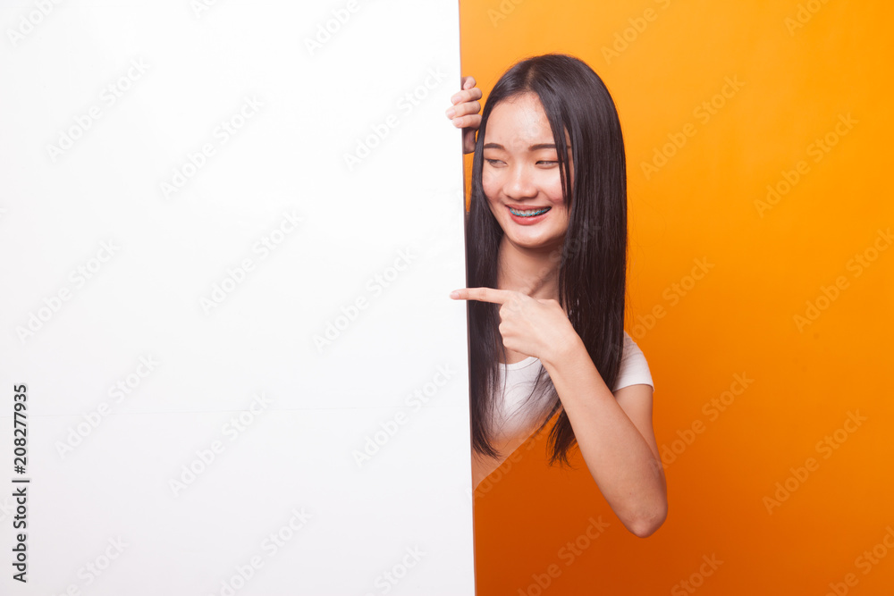 Young Asian woman point to a blank sign. Young Asian woman point to a blank sign.