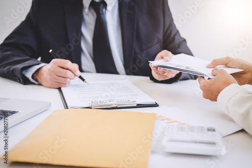 Bribery and corruption concept, bribe in the form of dollar bills, Businessman giving money in the envelope while making deal to agreement a real estate contract and financial corporate