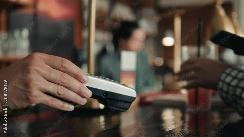 Close-up shot of unrecognizable man using mobile phone nfc payment banking in order to pay for to go coffee at lovely cafe, close-up shot Close-up shot of unrecognizable man using mobile phone nfc payment banking in order to pay for to go coffee at lovely cafe, close-up shot