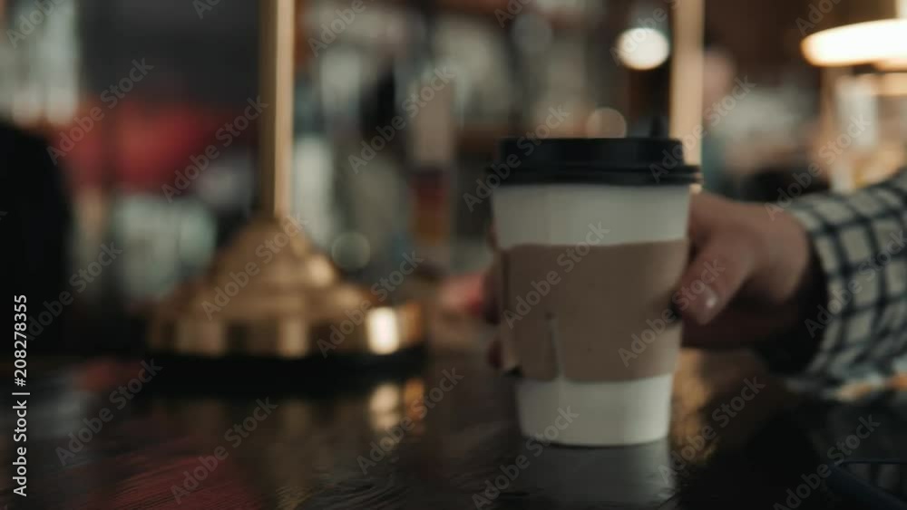 Close-up shot of unrecognizable man using mobile phone nfc payment banking in order to pay for to go coffee at lovely cafe, close-up shot