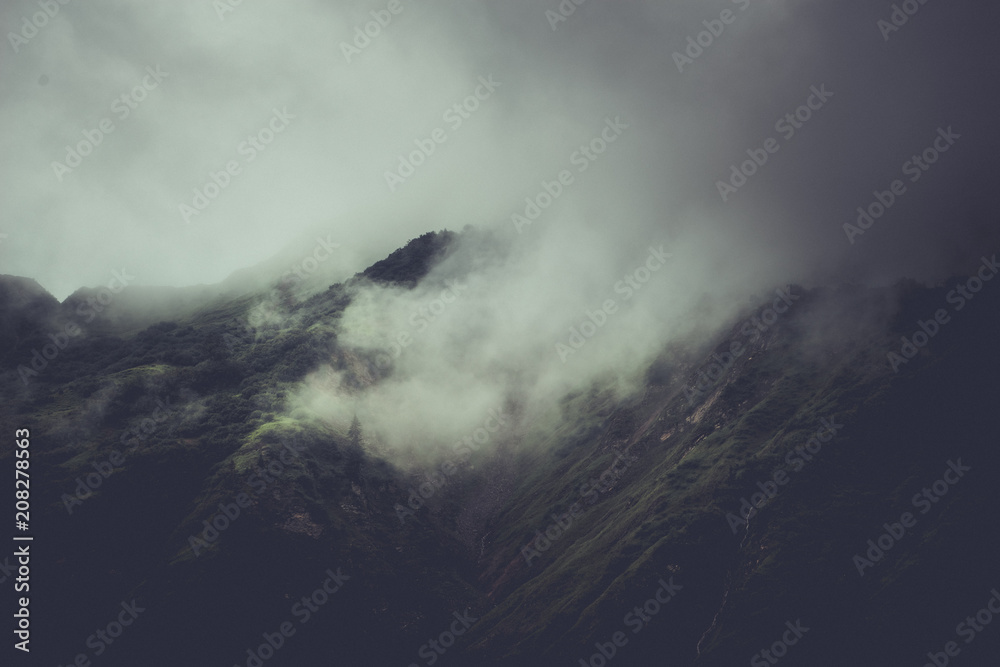 Storm clouds closing in on high mountain peaks Storm clouds closing in on high mountain peaks