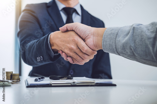 Handshake of cooperation customer and salesman after agreement, successful car loan contract buying or selling new vehicle photo