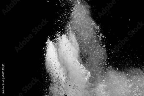 Bizarre forms of white powder explosion cloud against dark background. Launched white particle splash on black background.