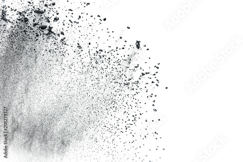 Black powder explosion against white background.Closeup of black dust particles explode isolated on white background.