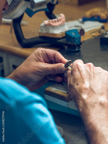 Crop man polishing denture