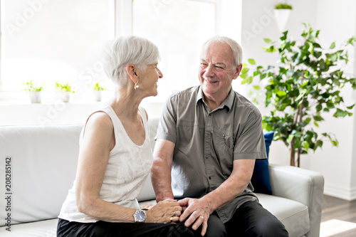 Affectionate attractive elderly couple sitting together on a couch