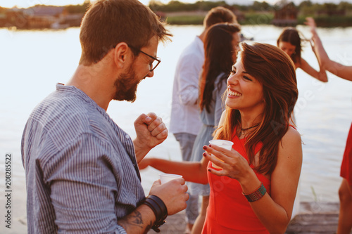 Man and woman flirting at party by the river