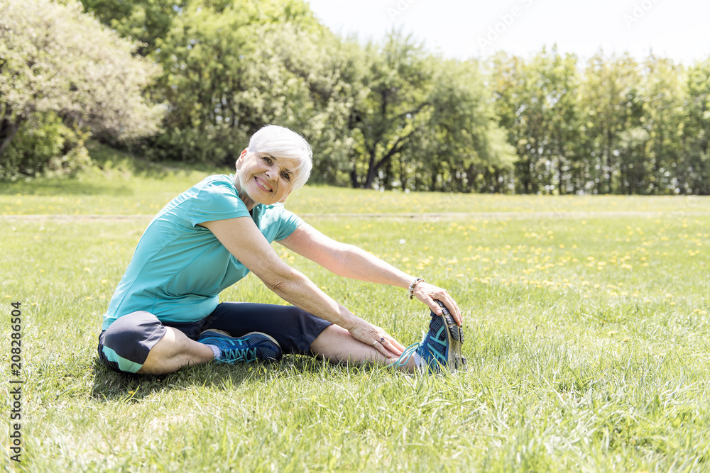 Senior Woman stretching In Park Senior Woman stretching In Park