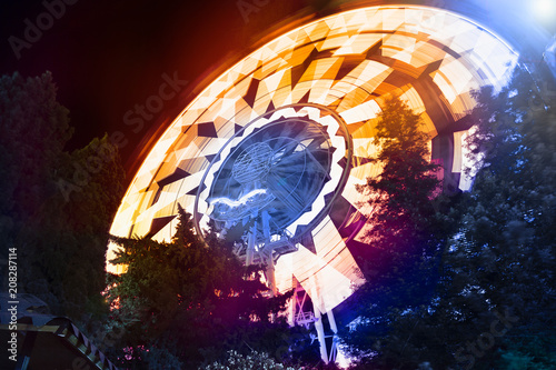 Ferris wheel photographed at long exposure. Night attractions. Night Park with attractions.
