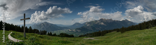 mountain panorama with a gorgeous view of the Swiss Alps and Valleys and a summit cross 