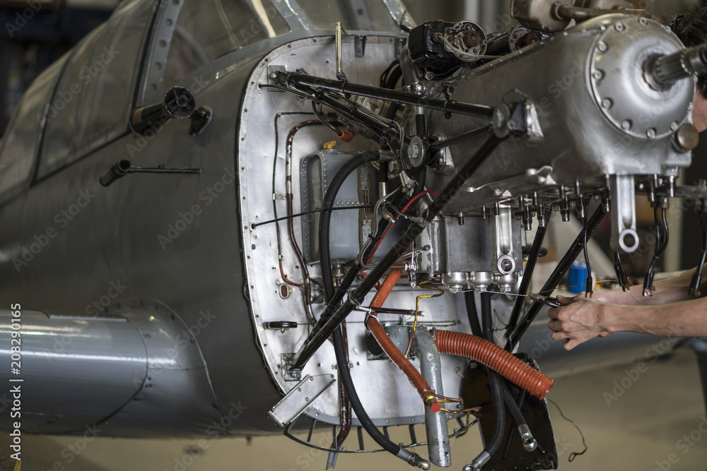 Crop hands repairing plane engine Crop hands repairing plane engine
