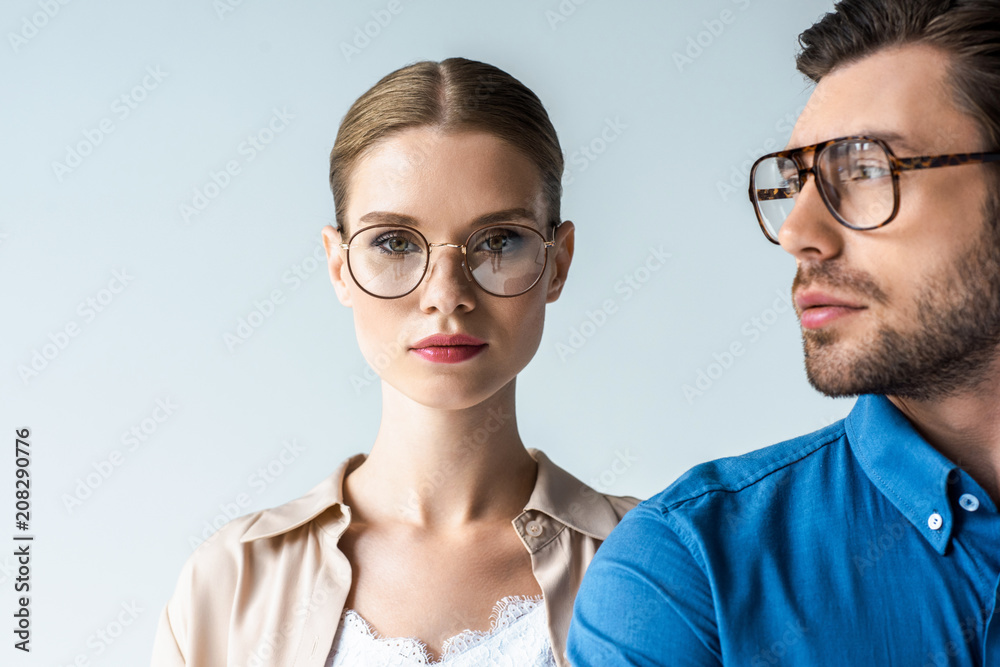 close-up portrait of young man and woman in stylish clothing and eyeglasses isolated on white - obrazy, fototapety, plakaty 