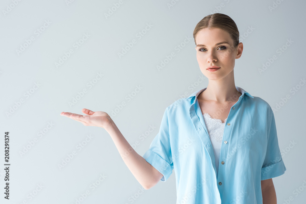 beautiful young woman in blue shirt pointing at blank space isolated on grey beautiful young woman in blue shirt pointing at blank space isolated on grey
