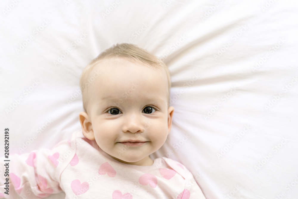 Adorable baby girl cover with white sheet wearing pink clothes Adorable baby girl cover with white sheet wearing pink clothes