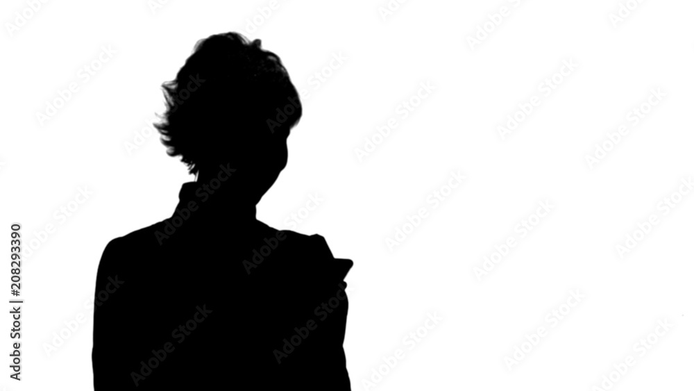 Silhouette Young attractive woman works on smartphone and smiles track matte