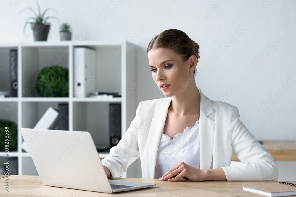 concentrated young businesswoman working with laptop at office concentrated young businesswoman working with laptop at office