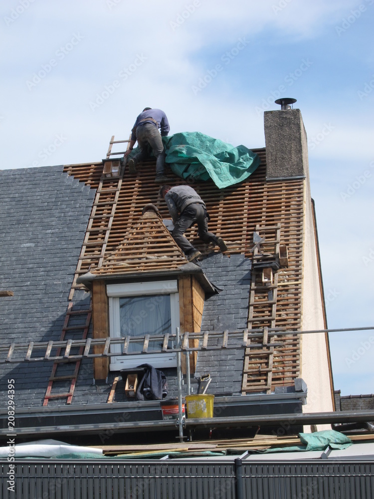 Naklejka premium PLERIN, FRANCE 06 APRIL, 2018: Roofing workers on a roof at Plerin