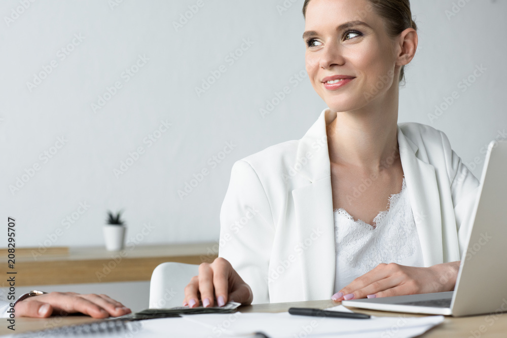 young smiling businesswoman taking bribe at office young smiling businesswoman taking bribe at office