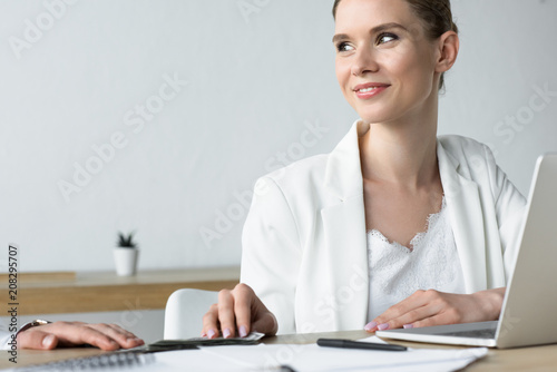 young smiling businesswoman taking bribe at office