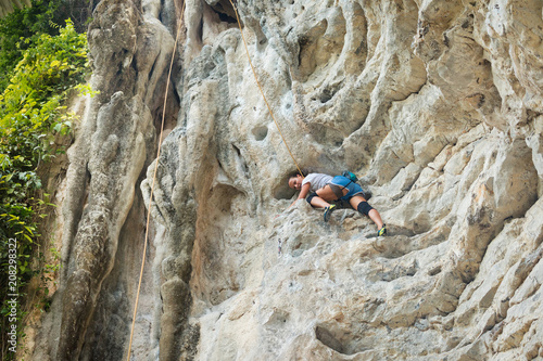 Young woman rock climbing on white mountain