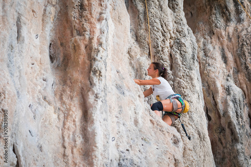 Young woman rock climbing on white mountain