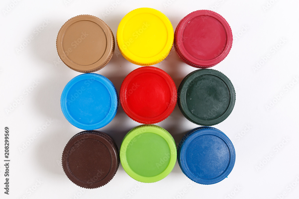 multi-colored paint in jars with tassels on a white background multi-colored paint in jars with tassels on a white background