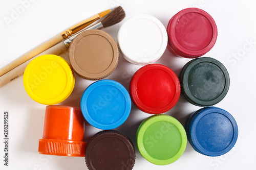 multi-colored paint in jars with tassels on a white background.