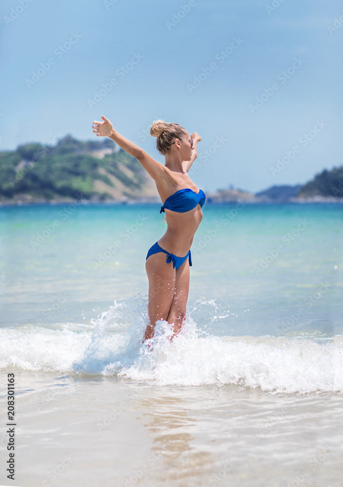 Young pretty blond woman in blue bikini on white tropic beach Young pretty blond woman in blue bikini on white tropic beach