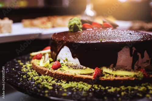 Konstfotografi Chocolate cake with strawberries and kiwi