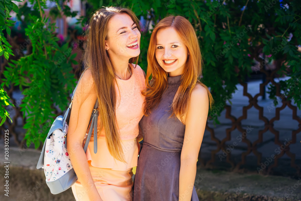 sincere smiles of the best friends who have fun time. Close-up of girls in beautiful dresses