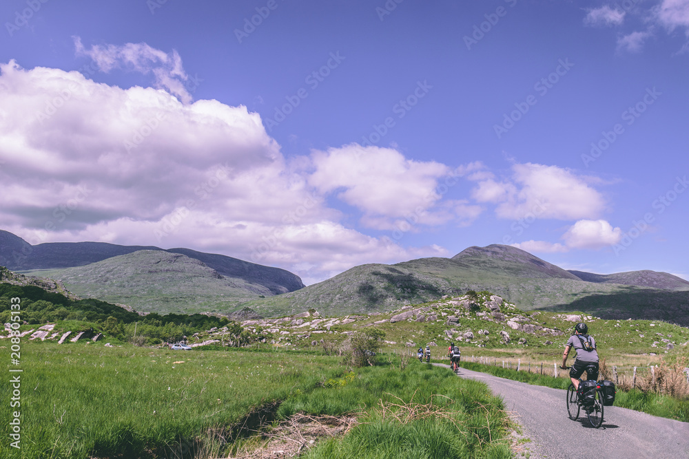 Fototapeta premium People riding bicycles on the scenic roads of Black Valley in county Kerry, Ireland