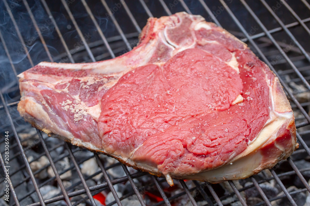 Close-up of a raw beef rib on a barbecue grill