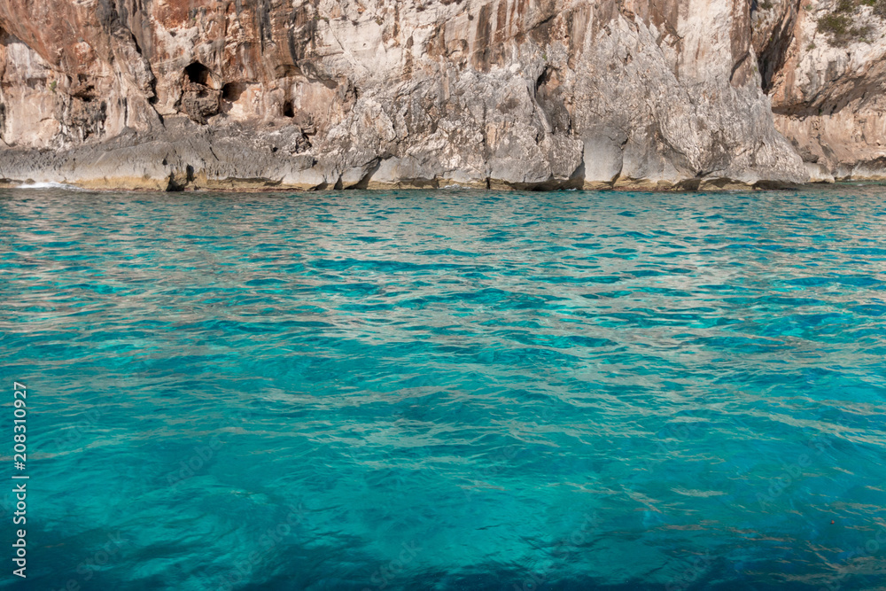 Turquoise colored water in front of coastal cliff Turquoise colored water in front of coastal cliff