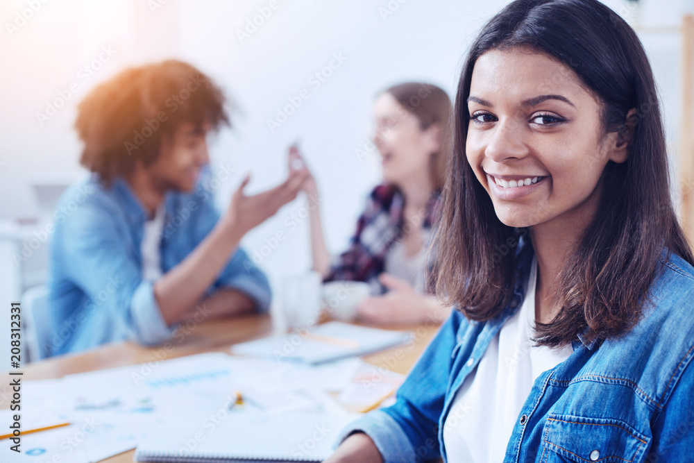 My group. Beautiful brunette girl keeping smile on her face and sitting in semi position while looking forward My group. Beautiful brunette girl keeping smile on her face and sitting in semi position while looking forward