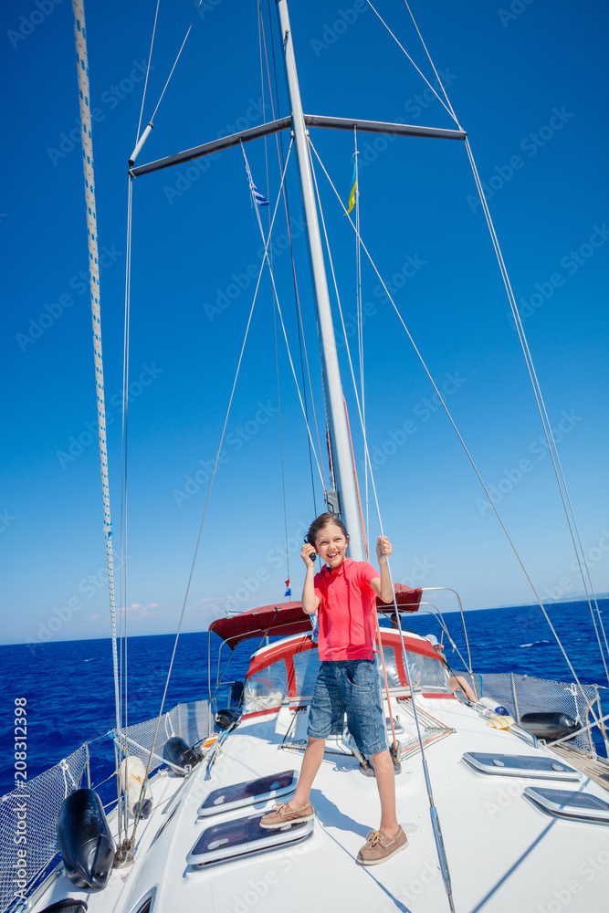 Little boy on board of sailing yacht on summer cruise. Travel adventure, yachting with child on family vacation. Little boy on board of sailing yacht on summer cruise. Travel adventure, yachting with child on family vacation.