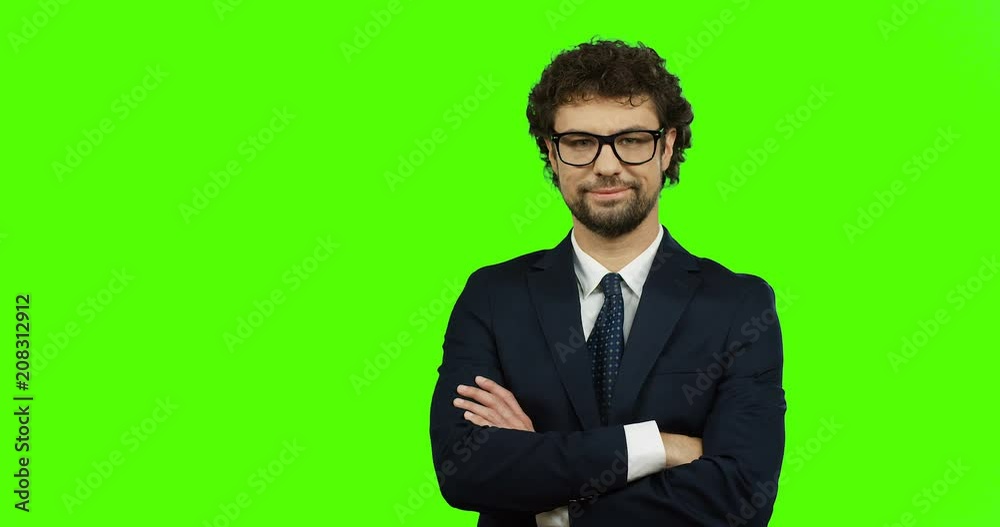 Portrait shot of the attractive man smiling in front of the camera and crossing his hands on the green screen. Chroma key. Portrait shot of the attractive man smiling in front of the camera and crossing his hands on the green screen. Chroma key.