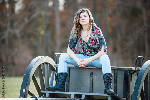 Young woman sitting manspreading womanspreading spreading legs on old cannon carriage in Manassas National Battlefield Park in Virginia where Bull Run battle was fought photo