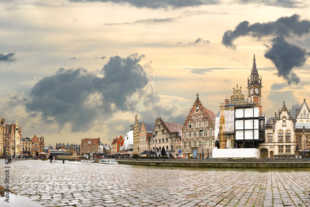 Golden sunset and dramatic clouds over historic buildings in medieval Belgian city Ghent - one of the most attractive touristic places in Europe