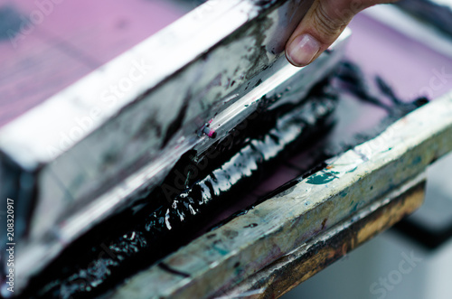 close up of hands holding a spatula with black ink