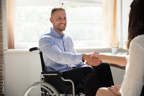 Disabled Businessman Shaking Hand With His Partner photo