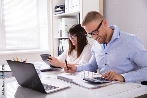 Two Businesspeople Calculating Invoice