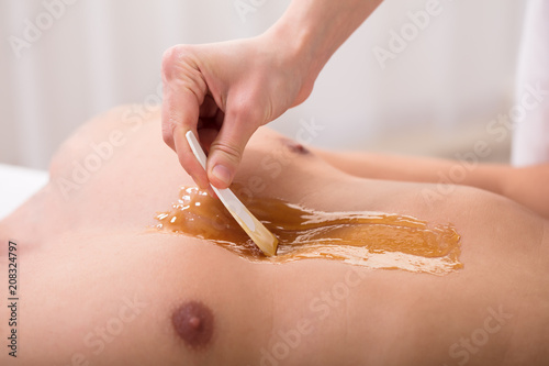Fotografía Beautician Applying Wax On Man's Chest