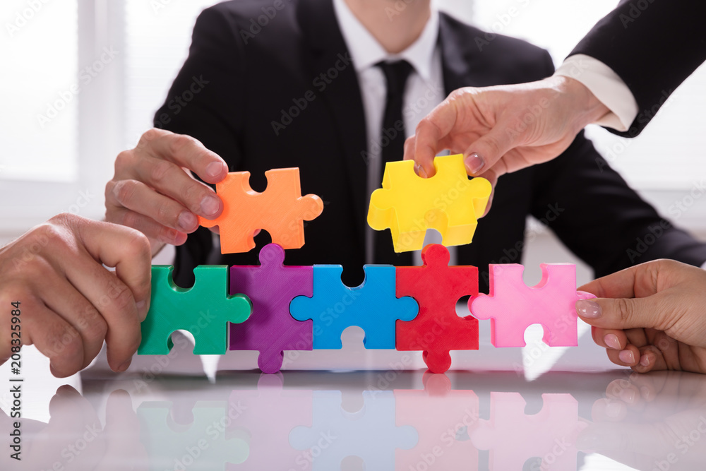 Group Of Businesspeople Solving Jigsaw Puzzle Group Of Businesspeople Solving Jigsaw Puzzle