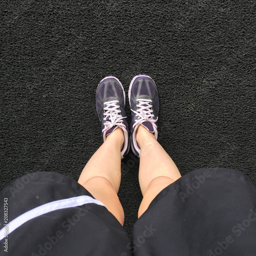 Female in Purple Sneakers Shoes Isolated. Top View. Woman Wear Runner Sneakers Urban on Cement Background