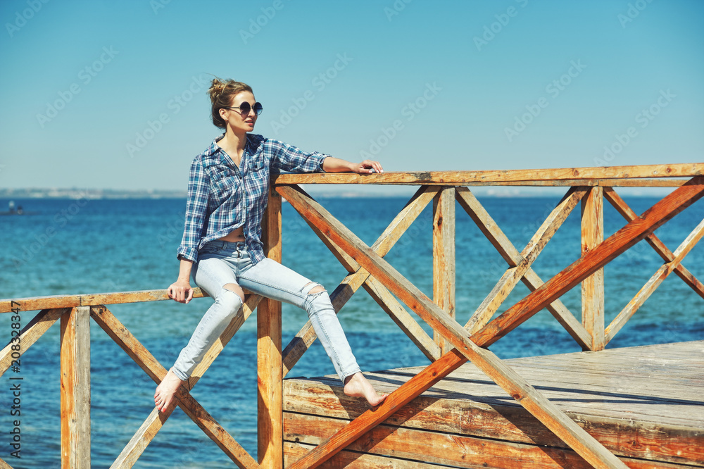 Portrait of a young woman on the beach. Girl resting on the seashore Portrait of a young woman on the beach. Girl resting on the seashore