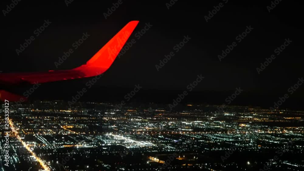 Bangkok, Thailand- Jun 4, 2018. Thai Airasia airline flight FD 3010 fly from Phuket (HKT) to Donmuang Bangkok (DMK) is landing. View from window seat Illuminated city in dark night. 