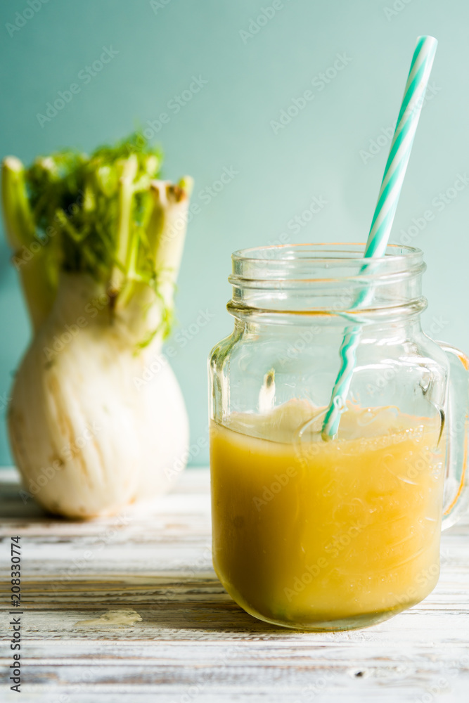 Fennel Juice on a jar glass over a rsty white board agaainst a blue background, selective focus Fennel Juice on a jar glass over a rsty white board agaainst a blue background, selective focus