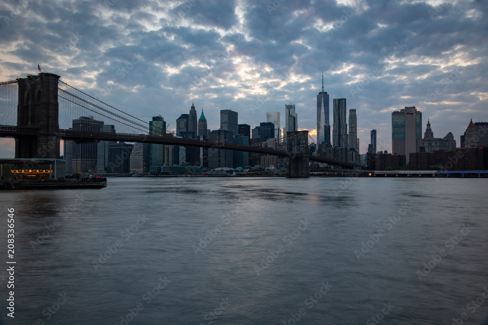 New York skyline at dusk with the Brooklyn Bridge in the foreground