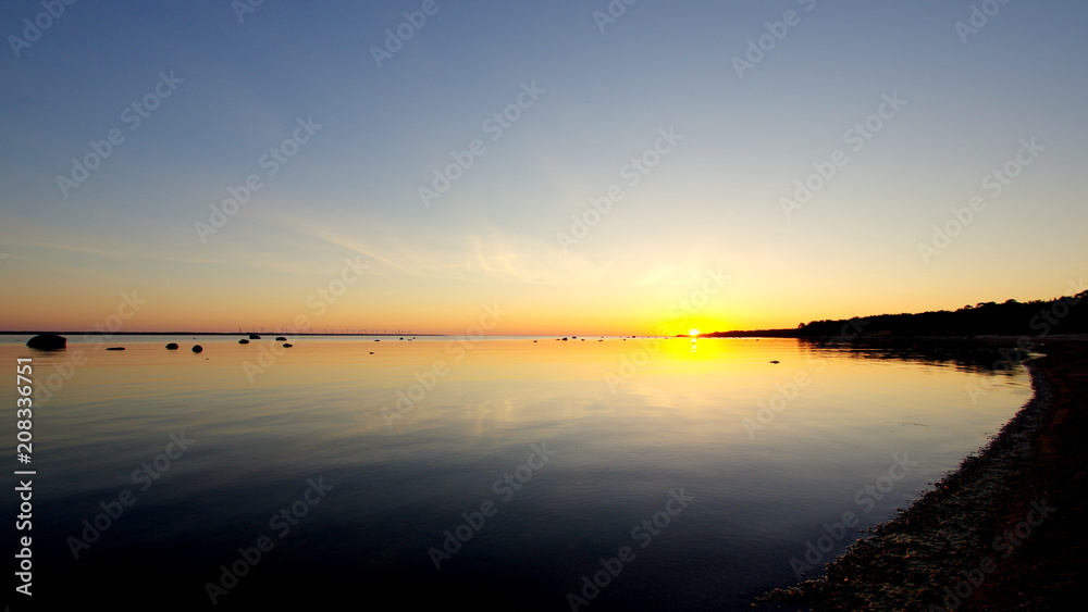 Piękny zachód słońca nad bałtyckim morzem, przy niebiańskiej plaży