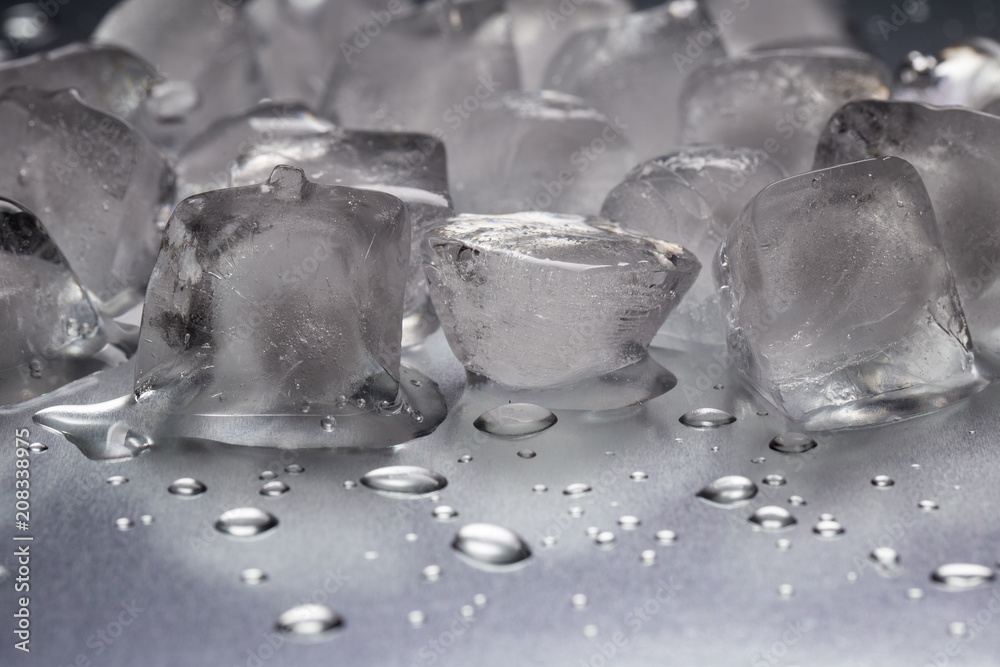 Ice cubes on a reflecting table with drops of water close-up Ice cubes on a reflecting table with drops of water close-up